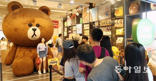 24일 서울 강남구 라인프렌즈 플래그십 스토어 가로수길점에서 방문객들이 곰 캐릭터인 대형 ‘브라운’ 인형과 사진을 찍기 위해 줄을 서서 기다리고 있다. 양회성 기자 yohan@donga.com