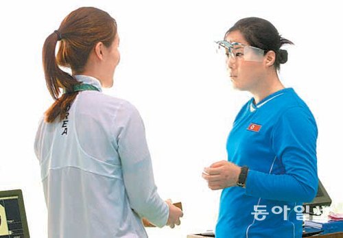 한국 사격대표팀의 황성은(왼쪽)이 지난달 29일(현지 시간) 리우데자네이루 올림픽 슈팅센터에서 훈련을 하던 도중 북한의 조영숙에게 빵을 건네고 있다. 리우데자네이루=김재명 기자 base@donga.com