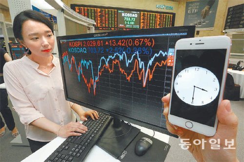 주식 거래시간이 30분 연장된 1일 서울 영등포구 여의나루로 한국거래소 홍보관에서 한 직원이 오후 3시 30분 마감된 코스피 종가 등이 표시된 컴퓨터 모니터 옆에서 일하고 있다. 전영한 기자 scoopjyh@donga.com