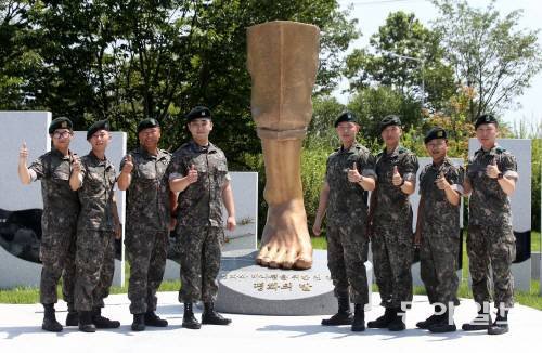 4일 경기 파주시 임진각에서 열린 북한의 비무장지대(DMZ) 지뢰 도발 1주년 행사에 참석한 육군 1사단 수색대원들이 기념 조형물
 앞에서 구호를 외치고 있다. 왼쪽부터 박준호 예비역 병장, 이형민 하사, 박선일 원사, 하재헌 하사, 김정원 하사, 정교성 
중사, 최유성 예비역 병장, 문시준 중위. 파주=장승윤 기자 tomato99@donga.com