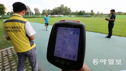 3일 서울 동작구의 한 공원을 찾은 한국건설생활환경시험연구원 연구원들이 휴대용 측정기로 우레탄 트랙에서 나오는 중금속의 양을 측정하고 있다. 전영한 기자 scoopjyh@donga.com