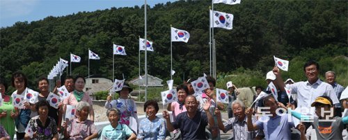 10일 인천 강화군 최북단 섬 아차도에서 주민들과 보훈단체 회원들이 태극기를 흔들고 있다. 아차도 주민들은 성금을 모아 섬 전역에 태극기 게양대 47개를 세웠다. 아차도=신원건 기자 laputa@donga.com