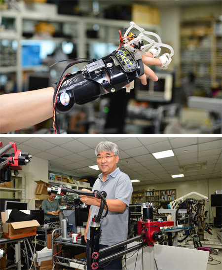 오용환 한국과학기술연구원(KIST) 로봇연구단장팀이 개발하고 있는 가상역감장비(아래사진). 로봇팔 두 개로 이뤄져 있는 역감장비는 상하좌우로 잡아당기면 10kg짜리 물건을 드는 느낌을 준다. 오 단장팀은 장갑형 가상촉감 장비도 개발하고 있는데, 얇은 플라스틱판을 모터로 움직여 손가락 끝에 촉감을 준다. 한국과학기술연구원 제공