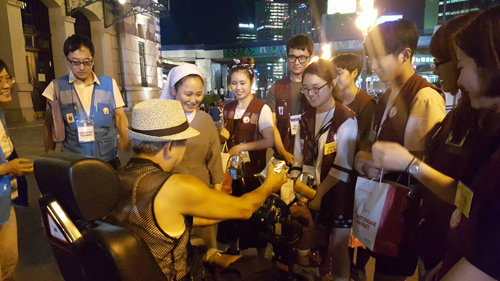 충북 음성군 꽃동네에서 속옷 포장 봉사활동을 한 한일 대학생들이 17일 저녁 서울역을 찾아 포장한 속옷을 노숙인에게 나눠주고 있다. 가톨릭대 제공