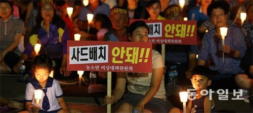 촛불집회 나선 김천 주민들 22일 경북 김천시 농소면사무소 마당에서 열린 촛불집회에 참석한 주민들이 
사드 배치에 반대하는 팻말과 촛불을 들고 있다. 사드의 제3후보지로 롯데스카이힐 성주컨트리클럽이 거론되면서 이곳에서 가까운 
김천지역 주민들이 크게 반발하고 나섰다. 김천=전영한 기자 scoopjyh@donga.com