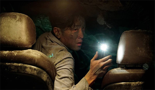 영화 ‘터널’의 한 장면. 무너진 터널에 갇힌 하정우는 갖가지 방법으로 구조를 요청해 보지만 상황은 나아질 기미를 보이지 않는다.