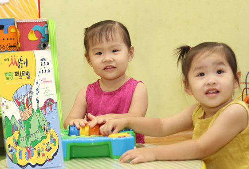 쌍둥이들이 행사 포스터를 바라보는 모습. 단양군 제공