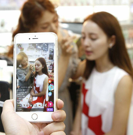 뷰티 분야에서 활동하고 있는 중국의 ‘왕훙’ 위샤오샤오 씨가 올해 6월 한국의 한 화장품 브랜드가 마련한 ‘한류 메이크업 쇼’에서 스마트폰 애플리케이션을 이용해 행사 내용을 생중계하고 있다. 라비오뜨 제공