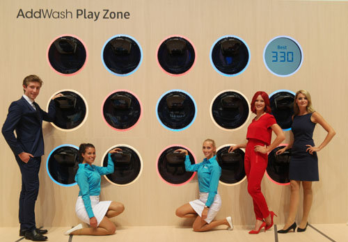 IFA걸(왼쪽에서 4번째)과 삼성전자 모델들이  ‘시티큐브 베를린’ 전시장에서 세탁 중간에 간편하게 세탁물이나 유연제 등을 투입할 수 있어 시간과 에너지의 절약을 실현한 애드워시를 소개하고 있다. 사진제공=삼성전자