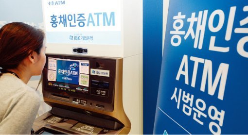 서울 을지로 IBK기업은행 본점에서 한 직원이 홍채인증 현금자동입출금기(ATM)를 이용하고 있다. IBK기업은행은 직원들을 대상으로 홍채인증 ATM을 시범운영하고 있다. [뉴스1]