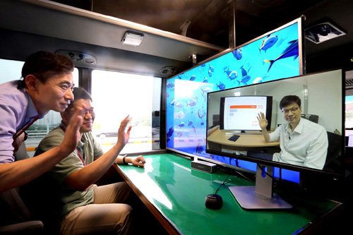 20일 SK텔레콤 분당사옥 주변에서 SK텔레콤 연구원과 삼성전자 연구원들이 밀리미터파 5G 시스템과 연동한 Full HD급 영상통화 및 UHD 스트리밍 서비스를 동시에 이동환경에서 시연하고 있다. 사진제공=SK텔레콤