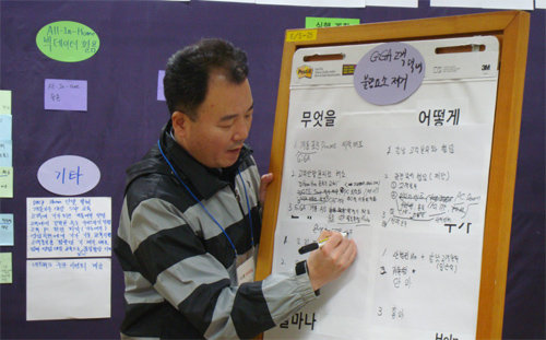 ▲ 2015년 3월 5일 열린 KT ‘1등 워크숍’에 참가한 한 직원이 토론 결과를 보드에 정리하고 있다. KT 제공