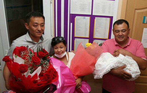 카자흐스탄의 비센갈리-자이나굴 부부 가족이 건강한 딸을 순산한 뒤 축하 꽃다발과 아이를 안고 기념촬영을 했다. 사진 가운데가 제일병원으로 정성껏 쓴 손편지를 보낸 자이나굴 씨다. 사진제공｜제일병원