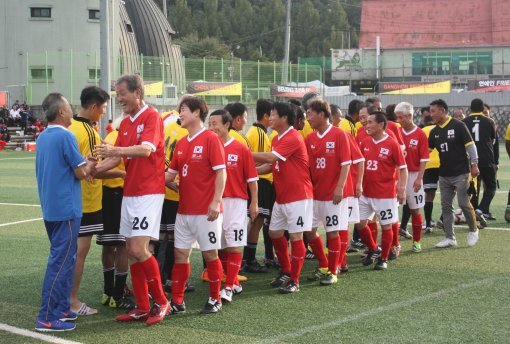 1일 강원 춘천시 공지천구장에서 열린 한국과 말레이시아의 축구 OB 팀 시합이 끝난 뒤 양 팀 선수들이 악수를 나누고 있다. 한국 OB 팀 맨 앞에 선 김재한이 말레이시아의 소친온을 보자 환하게 웃고 있다.