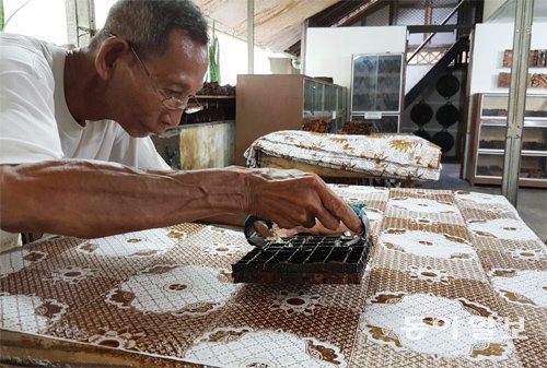 인도네시아 장인이 뜨거운 밀랍을 흰 천 위에 찍어 전통 문양인 ‘바틱’을 새기고 있다. 욕야카르타=이호재 기자 ho@donga.com