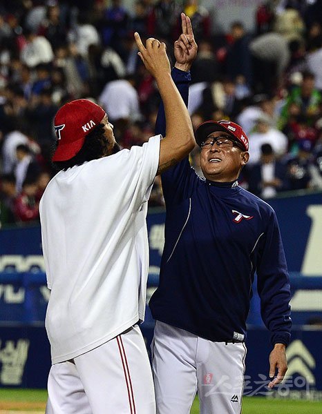 KIA 김기태 감독(오른쪽)과 헥터가 10일 잠실구장에서 열린 LG와 와일드카드 결정 1차전을 승리로 이끈 뒤 특유의 세리머니를 하며 기쁨을 만끽하고 있다. 이날 KIA는 4-2로 승리했고, 헥터는 7이닝 2실점(1자책점)의 호투로 승리투수가 돼 데일리 MVP를 거머쥐었다. 잠실｜ 김진환 기자 kwangshin00@donga.com