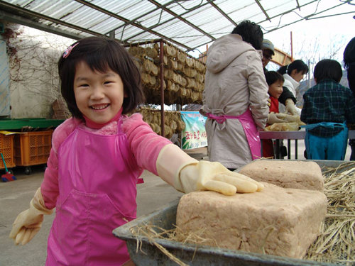 농촌체험 교육장을 방문한 아동이 ‘전통 발효식품 만들기’를 하며 환하게 웃고 있다. 농림축산식품부 제공