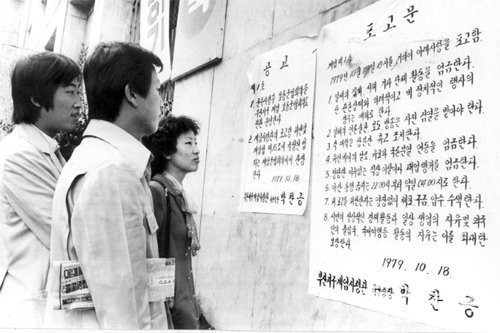 37년 전 부마항쟁 당시 부산 시내 곳곳에 붙었던 계엄포고문을 지나가던 시민들이 유심히 읽고 있다. 동아일보DB