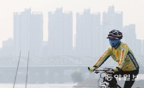 외출 땐 마스크 꼭 챙기세요 가을 하늘에 미세먼지가 가득한 14일 서울 한강시민공원 이촌지구에서 한 시민이 마스크를 쓴 채 자전거를 타고 있다. 국립환경과학원은 15일 오후부터 미세먼지가 차츰 사라질 것으로 내다봤다. 김재명 기자 base@donga.com
