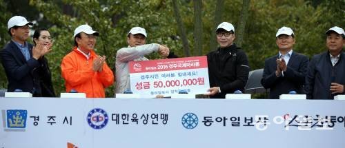 16일 열린 2016 경주국제마라톤에서 김재호 동아일보 사장이 최양식 경주시장에게 경주지진 피해 성금 5000만원을 전달하고 있다. 최혁중 기자 sajinman@donga.com