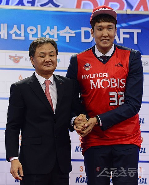 이종현(오른쪽)이 18일 잠실학생체육관에서 열린 ‘2016 KBL 국내신인선수 드래프트’에서 전체 1순위로 모비스의 선택을 받은 뒤 무대에 올라 유재학 감독의 손을 잡고 밝게 웃고 있다. 잠실｜김진환 기자 kwangshin00@donga.com