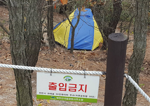 22일 오전 서울 은평구 북한산 족두리봉으로 올라가는 중턱의 보호구역 내에 한 등산객이 출입금지 푯말을 무시한 채 텐트를 치고 캠핑을 하고 있다.