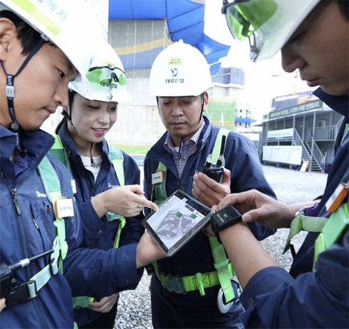 사물인터넷(IoT) 기술이 건설현장 안전관리에도 활용되기 시작했다. 대우건설의 ‘위례우남역 푸르지오’ 건설현장 직원들이 태블릿PC를 통해 현장 상황을 살펴보고 있다. 대우건설 제공