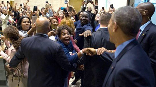 미국 일리노이 주 시카고 시청에 마련된 조기 투표소에서 7일 투표를 마친 버락 오바마 대통령(오른쪽에서 두 번째)이 한 흑인 여성에게 손을 뻗어 악수하고 있다. 사진 출처 백악관 홈페이지