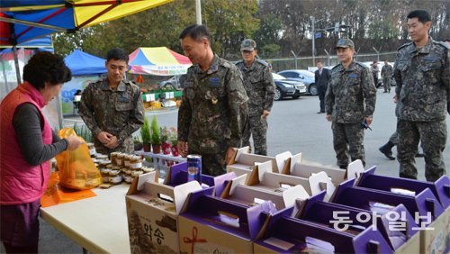 진광수 제17전투비행단장(가운데)이 4일 오후 부대 후문에 마련된 로컬푸드 직거래 장터에서 물건을 구입하고 있다. 장기우 기자 straw825@donga.com