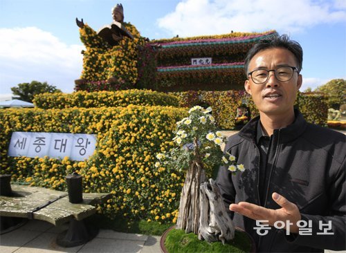 고찬훈 씨가 ‘대한민국 국향대전’이 한창인 1일 대형 국화 조형물 앞에서 자신의 국화 분재 작품을 설명하고있다. 국향대전이 가을 명품 축제로 성장한 데에는 그의 지극한 국화사랑이 있었다. 박영철 기자skyblue@donga.com