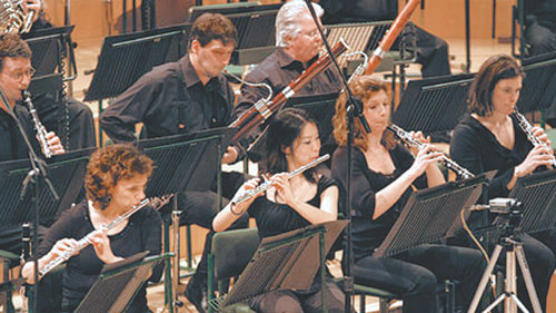 오케스트라 목관악기 주자들. 왼쪽 위부터 시계방향으로 클라리넷, 바순, 아랫줄에 오보에, 플루트 연주자.