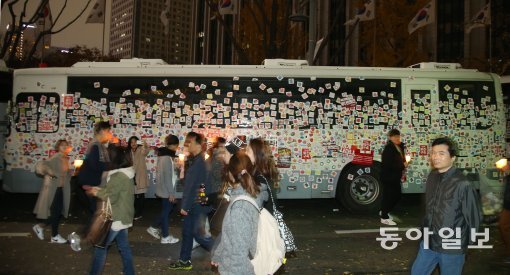 19일 오후 서울 광화문광장 일대에서 열린 4차 촛불집회에 참석한 시민들이 경찰 차벽에 꽃무늬 스티커를 붙여 평화시위를 염원하고 있다. 사진 김재명 기자 base@donga.com