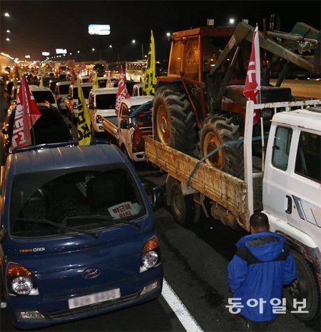 양재 나들목 경찰 저지선에 막혀… 5차 촛불집회를 하루 앞둔 25일 전국농민회총연맹 소속 농민들이 
‘트랙터 상경시위’를 위해 서울 진입을 시도하면서 서울과 경기 일대에서 경찰과 농민 사이에 대치와 충돌이 빚어졌다. 일부 트랙터를
 실은 트럭 150여 대가 서울 서초구 경부고속도로 양재 나들목 근처에서 경찰의 저지선에 막혀 길게 줄지어 서 있다. 전영한 기자
 scoopjyh@donga.com