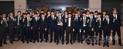 2016 아시아축구연맹(AFC) 챔피언스리그 우승을 차지한 전북현대 선수단이 27일 인천국제공항을 통해 개선했다. 최강희 감독(앞줄 오른쪽 7번째)과 우승트로피를 든 주장 권순태 등이 주먹을 불끈 쥔 채로 우승의 기쁨을 표현하고 있다. 인천국제공항 ｜ 김진환 기자 kwangshin00@donga.com