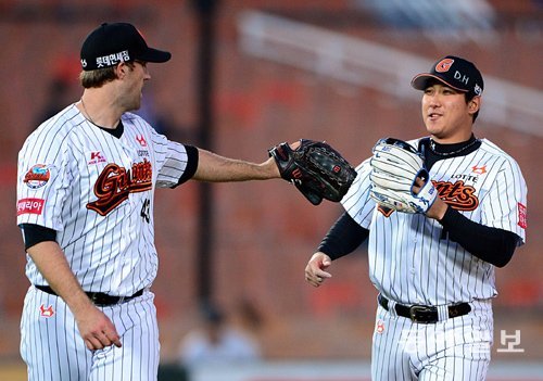 자유계약선수(FA) 자격으로 메이저리그에 도전하고 있는 황재균(오른쪽)은 동갑내기 외국인 선수 린드블럼과 자연스럽게 대화할 정도로 수준급의 영어 실력을 갖추고 있다. 두 선수가 올해 경기 도중 그라운드에서 글러브로 하이파이브를 하고 있다. 동아일보DB