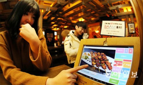 29일 서울 서초구 포차팩토리에서 전자 메뉴판으로 주문을 하는 손님들. 종업원과 마주치지 않고 주문할 수 있는 전자 메뉴판은 주로 혼자 식사를 하러 오는 사람들에게 인기다. 양회성 기자 yohan@donga.com