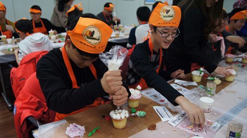 컵케이크를 꾸미는 체험에 참여하는 학생들의 모습.