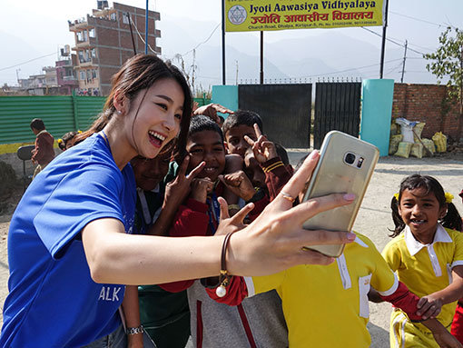 봉사활동에 참가한 ‘렛츠런엔젤스’가 네팔 어린이들과 셀카를 찍으며 즐거워하고 있다. 사진제공 ㅣ 한국마사회