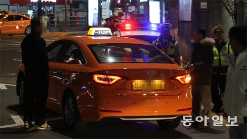 13일 새벽 서울 종로2가 사거리 부근에서 승차 거부를 당한 승객과 택시 운전사가 실랑이를 벌이자 경찰이 나서 해결하고 있다. 변영욱 기자 cut@donga.com