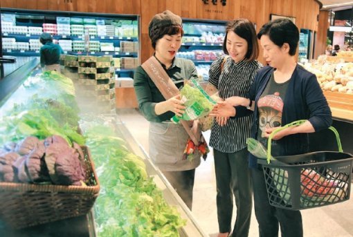 농림축산식품부는 친환경 농산물에 대한 소비자 신뢰를 제고하기 위해 인증 관련 제도를 대폭 정비했다. 현대백화점 판교점에 마련된 친환경 농산물 매장에서 고객들이 유기농 상추에 대한 설명을 듣고 있다. 농림축산식품부 제공