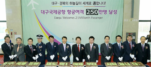 28일 대구국제공항에서 열린 항공여객 250만 명 달성 기념행사에서 권영진 대구시장(오른쪽에서 여섯 번째)과 성일환 한국공항공사 사장(오른쪽에서 일곱 번째) 등 참석자들이 축하 떡 케이크를 자르고 있다. 대구시 제공