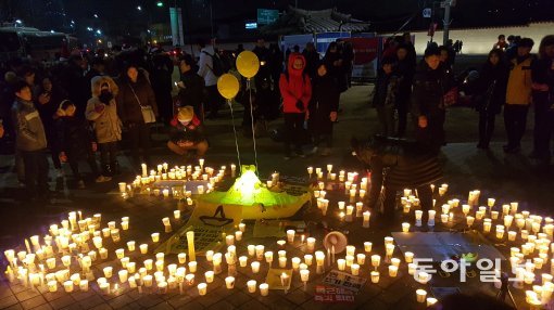 31일 서울 광화문광장에서 열린 ＇박근혜 대통령 퇴진 촉구 10차 촛불집회＇에 참여한 시민들이 세월호를 의미하는 노란 배 모형 주위에 촛불을 놓고 진상규명과 책임자 처벌 등을 촉구하고 있다. 서형석기자 skytree08@donga.com