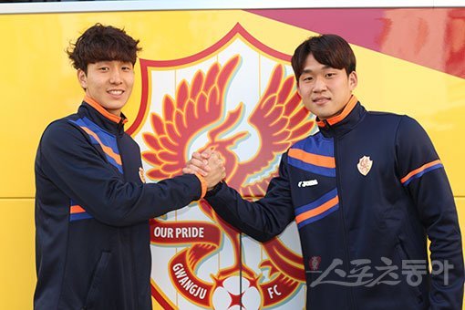 새 둥지 광주FC에서 도약을 노리는 이우혁(왼쪽)과 이한도가 구단 엠블럼 앞에서 올 시즌 선전을 다짐하고 있다. 광양 ｜ 남장현 기자 yoshike3@donga.com