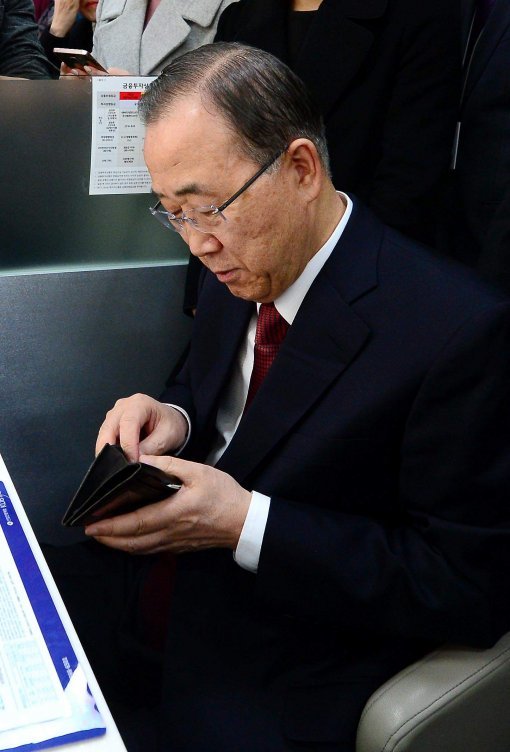 반기문 전 유엔 사무총장이 13일 오후 서울 마포구 KB국민은행 도화동지점에서 사업자우대 개인통장을 만들기 위해 창구에 앉아 지갑에서 통장에 입금할 돈을 꺼내고 있다. 반 전 총장은 이날 50만 원을 입금했다. 최혁중 기자 sajinman@donga.com