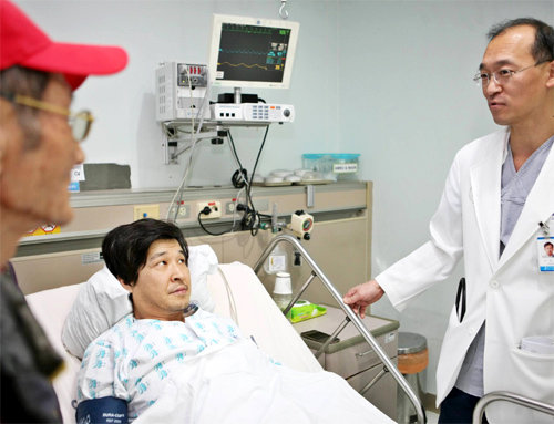 지난해 12월 급성심근경색으로 인하대병원 응급실로 실려와 긴급 시술을 받고 목숨을 건진 문주성 씨(가운데)가 주치의인 우성일 교수(심장내과, 심혈관센터장)와 대화를 나누고 있다. 문 씨는 새벽 귀갓길에 쓰러졌지만 빨리 119 구급차로 이송돼 골든타임을 놓치지 않았다. 인하대병원 제공