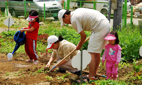 지난해 서울시 다둥이가족농장에서 한 가족이 텃밭에 씨를 뿌리고 물을 주고 있다. 서울시 제공