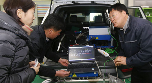 지난달 31일 교통환경연구소의 연구관이 기자(맨 왼쪽)에게 경유차 배기가스를 분석하는 법을 설명하고 있다.