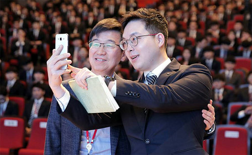 박성욱 SK하이닉스 부회장(왼쪽)이 10일 경기 이천 본사에서 한 신입사원에게 소장하고 있던 책을 선물한 뒤 함께 기념사진을 찍고 있다. SK하이닉스 제공