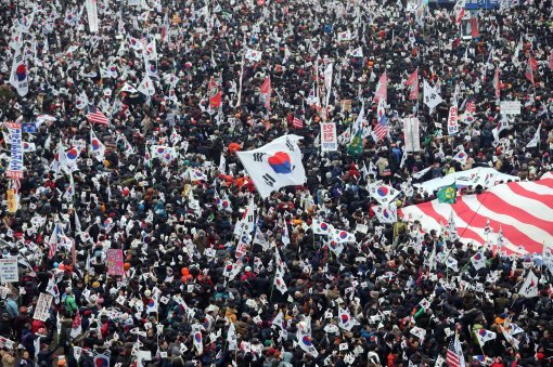 태극기와 성조기를 흔들며 박근혜 대통령 탄핵반대 시위를 벌인 보수단체 회원과 시민들.