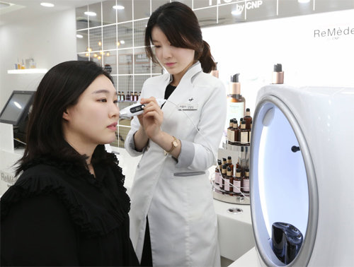 서울 서대문구 이화여대길 네이처컬렉션 이대점에 있는 ‘르메디 바이 씨앤피’에서는 정밀 피부 진단 이후 맞춤형 세럼을 제조할 수 있다. 직원이 수분측정기로 고객의 피부 상태를 측정하고 있다. LG생활건강 제공